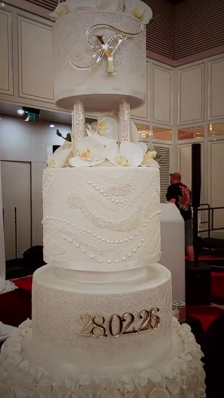 A tall wedding cake with carefully piped icing and delicate details