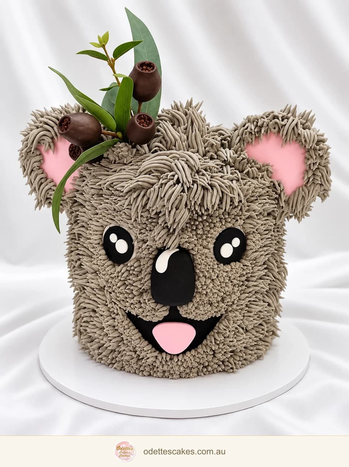 Koala birthday cake with textured grey icing, pink ears and eucalyptus details