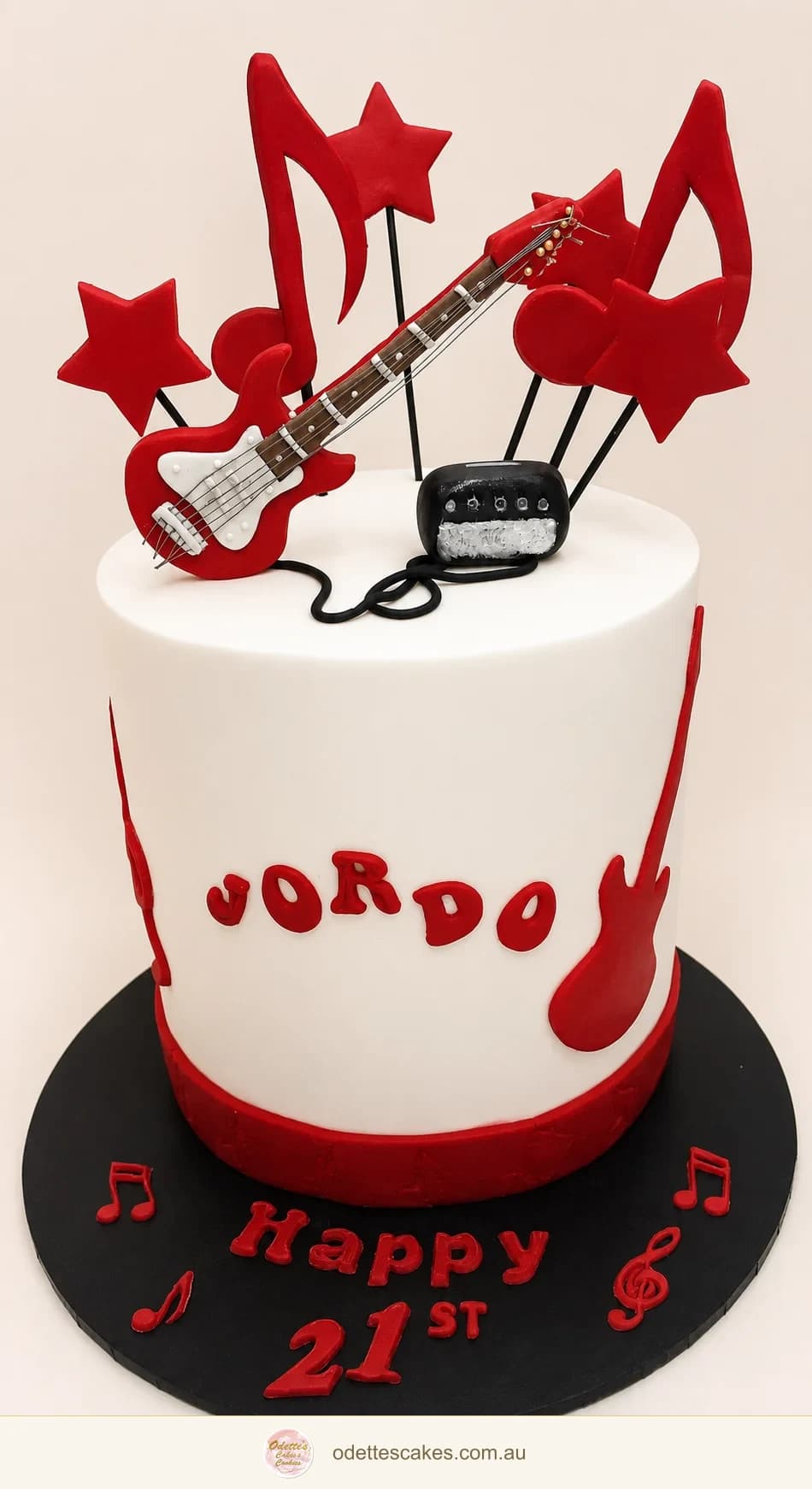 White 21st birthday cake with a red guitar, musical notes and star decorations