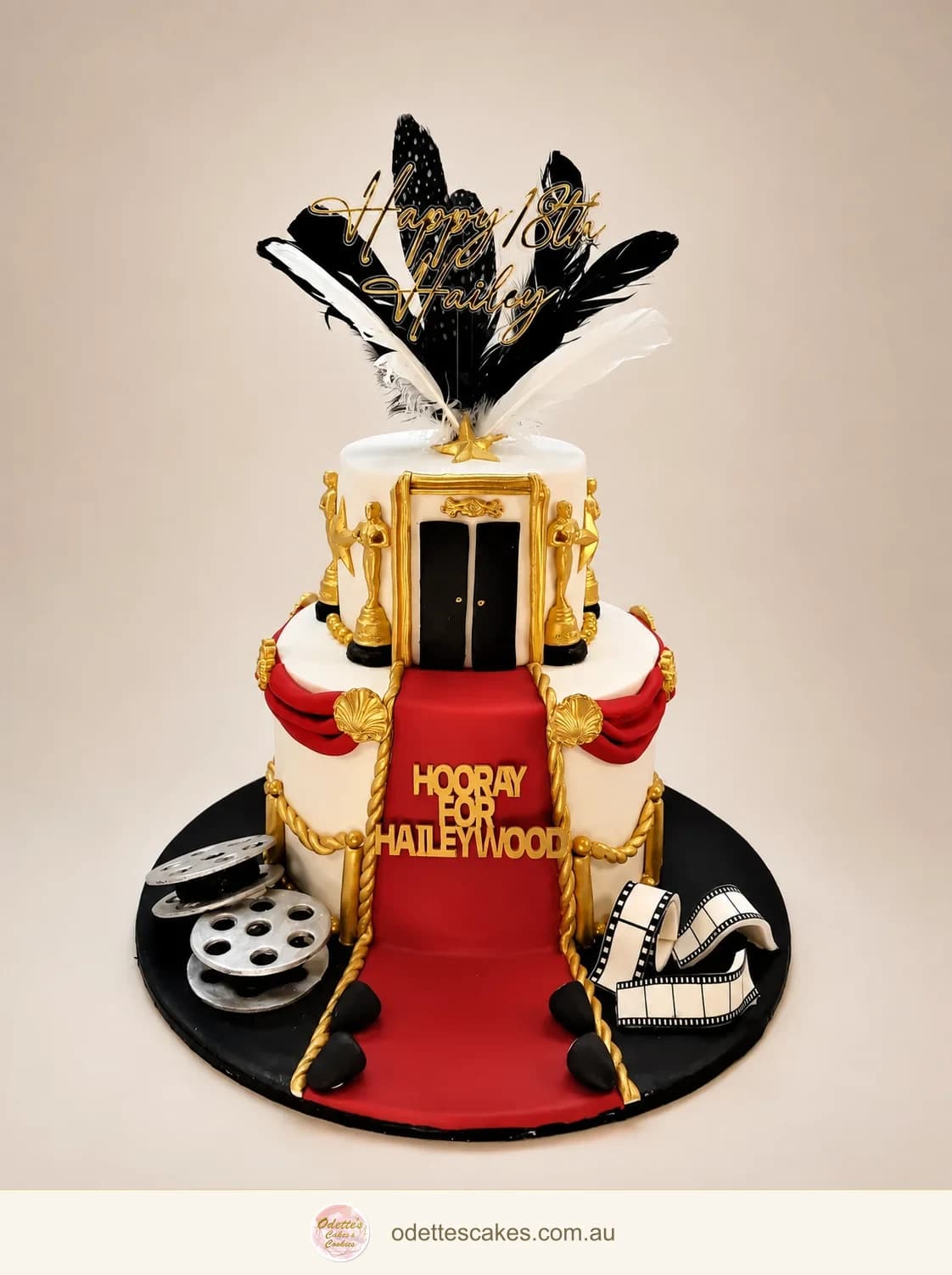 Hollywood-themed birthday cake with a red carpet, gold cinema details and film reels
