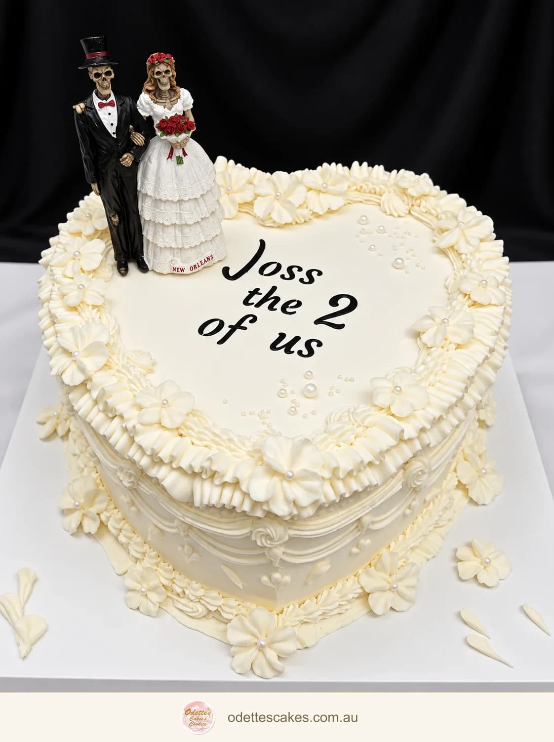 Ivory heart-shaped wedding cake with piped flowers, pearl details and a skeleton bride and groom topper, handmade in Jindalee, Perth