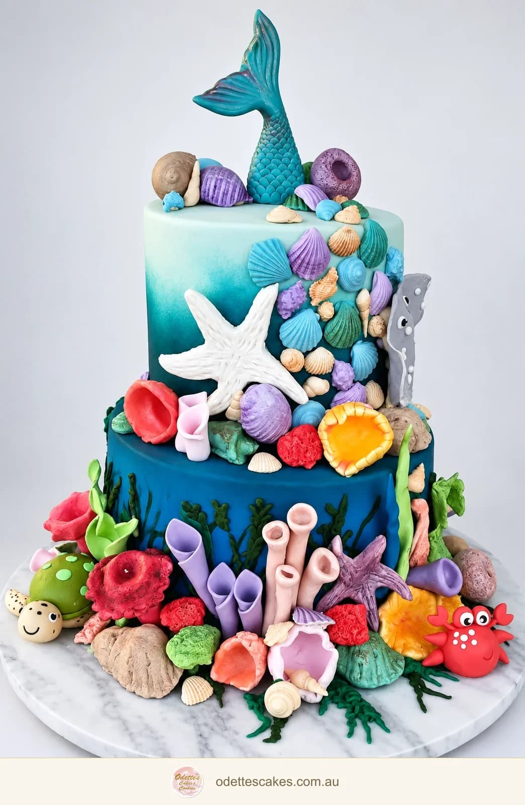 Two-tier ocean-themed birthday cake with a mermaid tail, shells, coral and colourful sea creatures