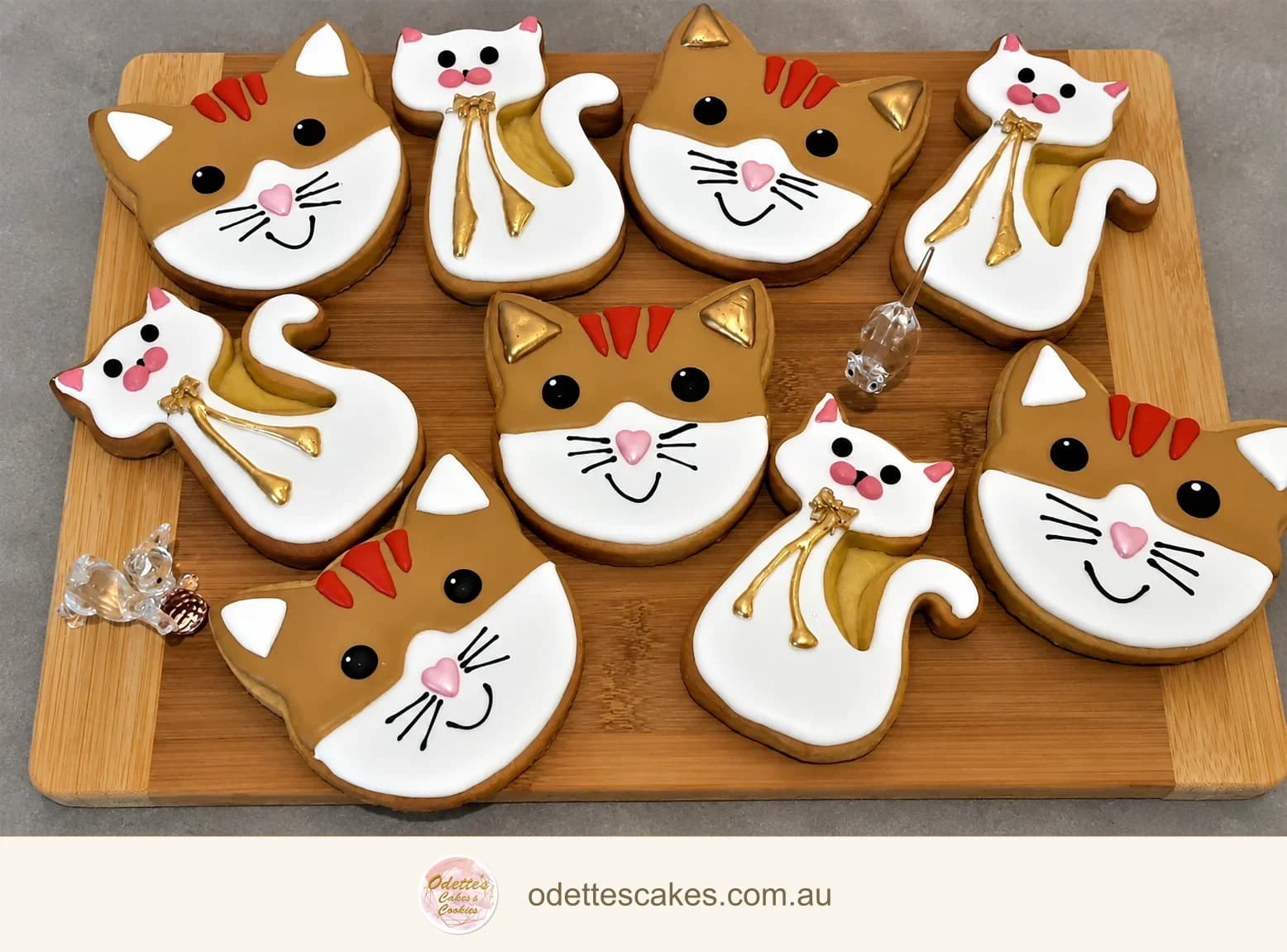 Hand-decorated cat-shaped cookies with white and ginger icing and tiny pink noses